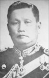 Field Marshal Sarit Thanarat (June 16, 1908 – December 8, 1963) was a Thai career soldier who staged a coup in 1957, thereafter serving as Thailand's Prime Minister until his death in 1963. He was born in Bangkok, but grew up in his mother's home town in Lao-speaking northeastern Thailand and considered himself a northeasterner. During his years as Prime Minister Sarit was a patron of the Lao strongman General Phoumi Nosavan against the communist Pathet Lao guerrillas in the neighboring Kingdom of Laos.<br/><br/>

Sarit's regime was the most repressive and authoritarian in modern Thai history, abrogating the constitution, dissolving parliament, and vesting all power in his newly-formed Revolutionary Party. Sarit banned all other political parties, imposing very strict censorship of the press after the coup.<br/><br/>

After Sarit's death, his reputation took a heavy blow when Sarit was discovered to have owned a trust company, a brewery, 51 cars, and some 30 plots of land, most of which he gave to the dozens of mistresses he was found to have had. Thai language newspapers published the names of 100 women who claimed to have shared his bed, shocking the public when it was learnt how corrupt he had actually been.