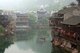 China: Boatman collecting river weed early morning on Fenghuang's Tuo River, Fenghuang, Hunan Province